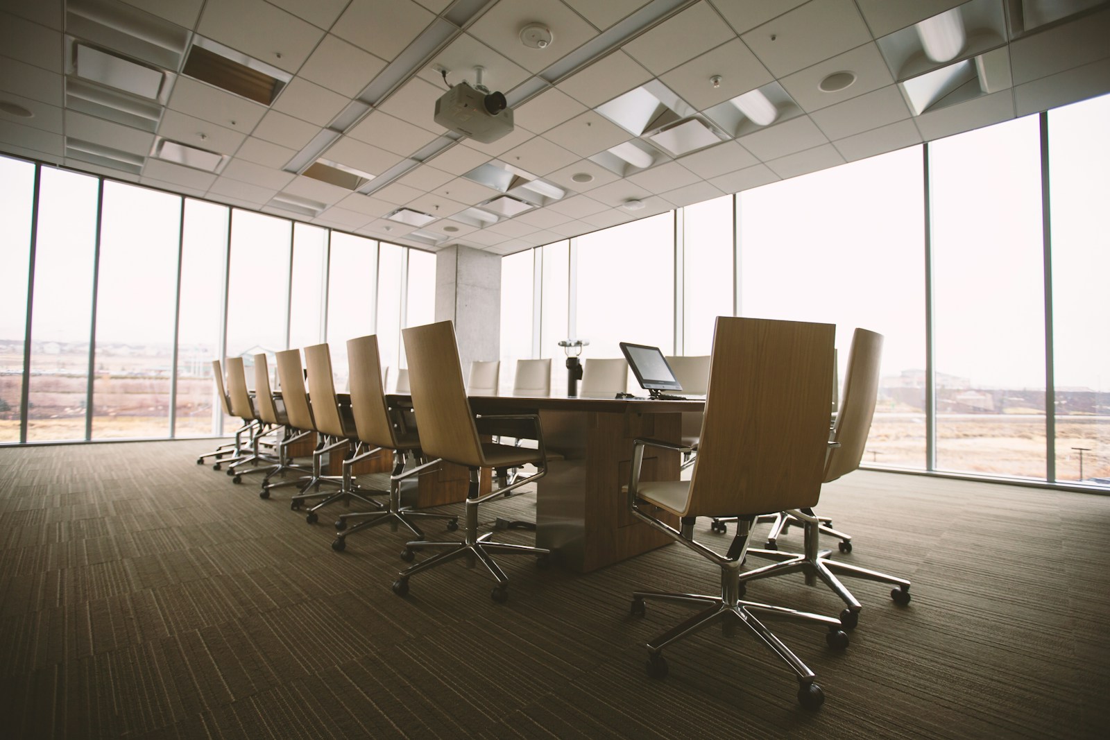 Empty executive meeting room with a long table and floor-to-ceiling windows
